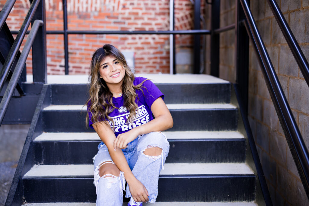 girl sitting on steps wearing purple shirt 