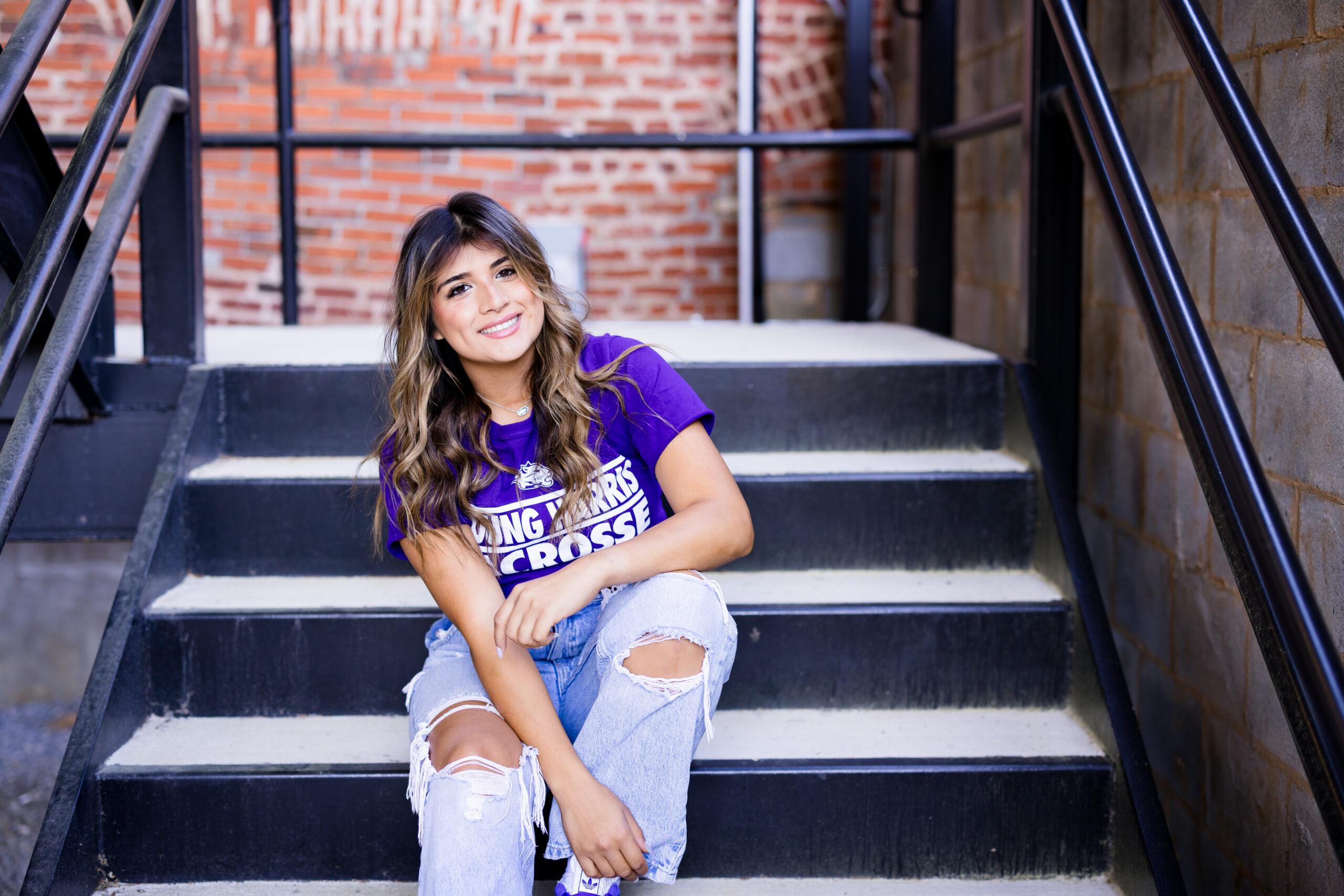 girl sitting on steps in purple young harris shirt
