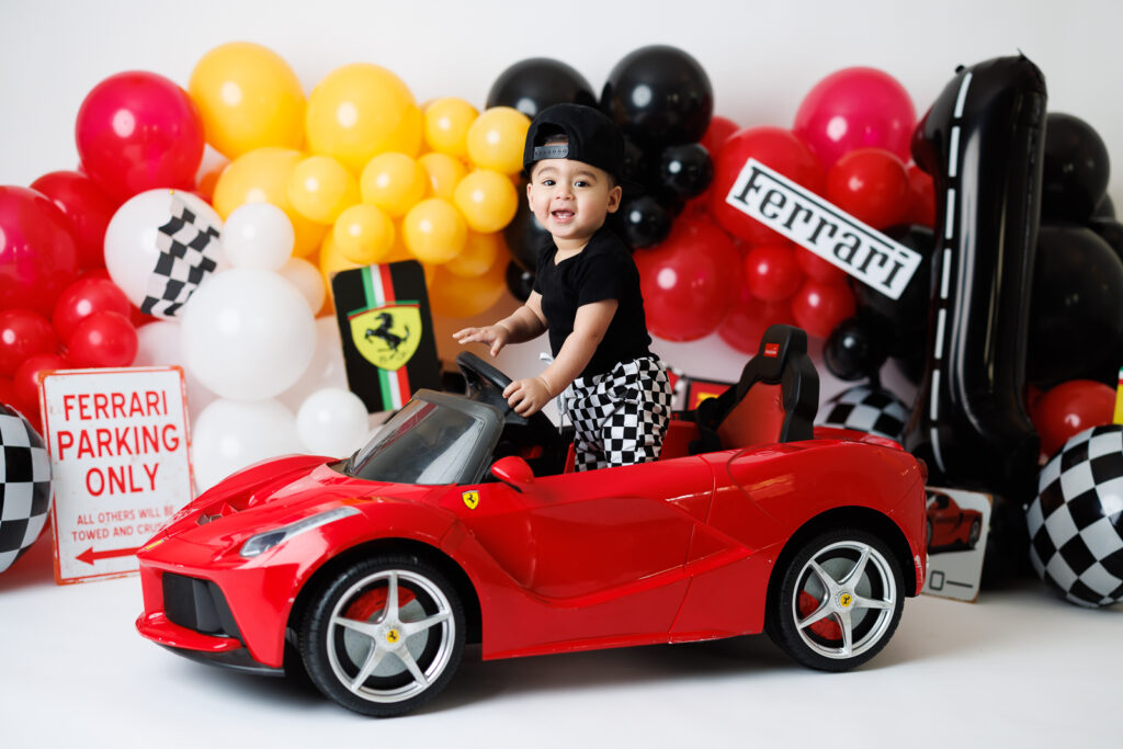 boy in red ferrari car posing 