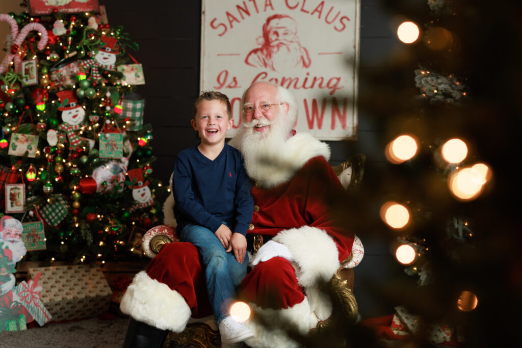 child laughing with santa christmas tree 