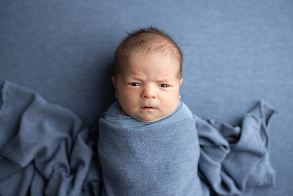 awake newborn pose blue blanket canton ga