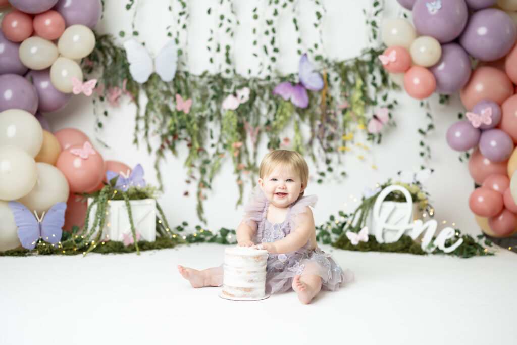 girl in purple fairy themed cake smash