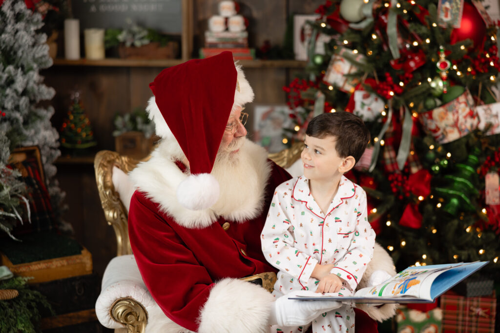 christmas pajamas reading santa. a book