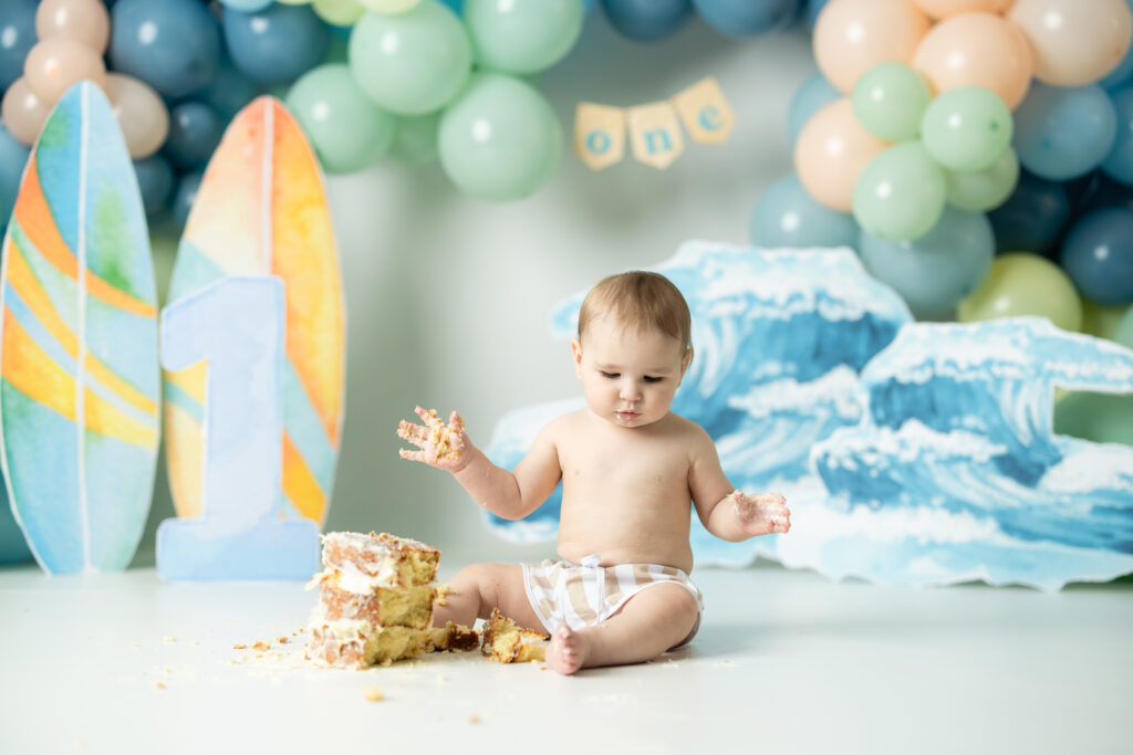 boy playing in cake for first birthday pictures 