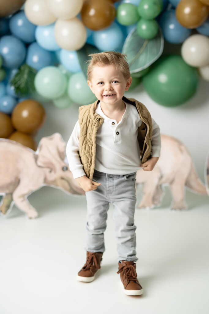 boy giggling at dinosaur themed birthday pictures 