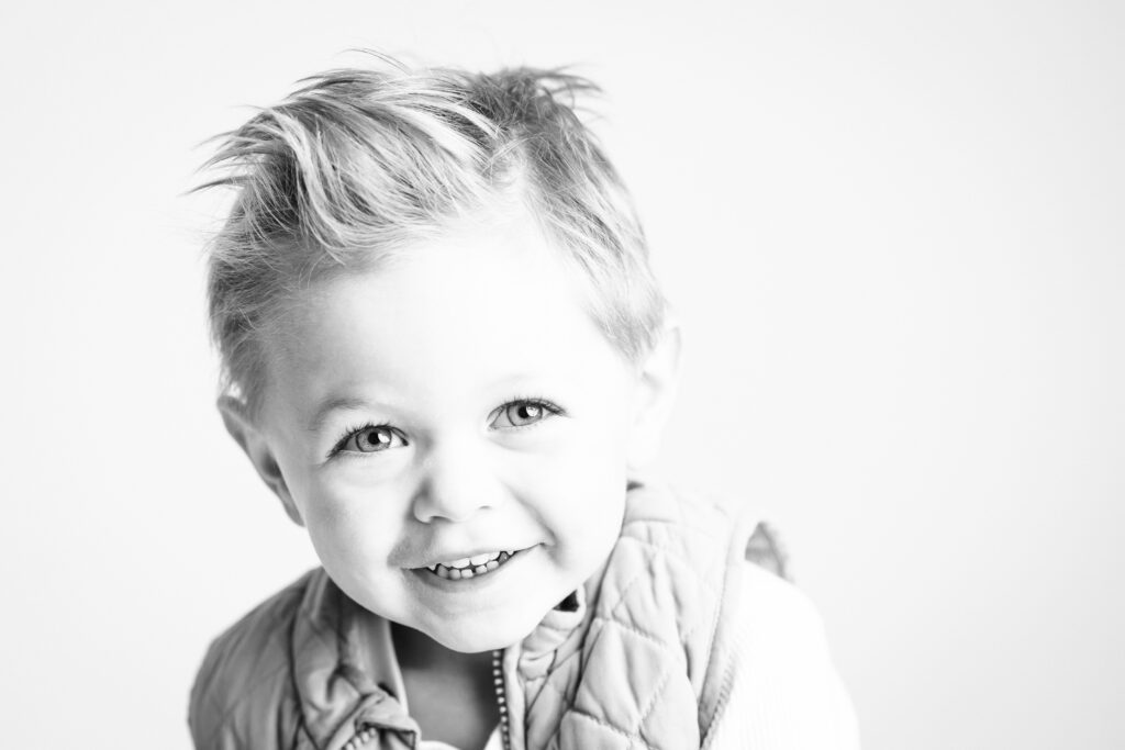 black and white photo of little boy smiling