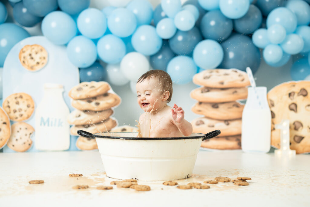 baby splashing in milk bath full of chocolate chip cookies 