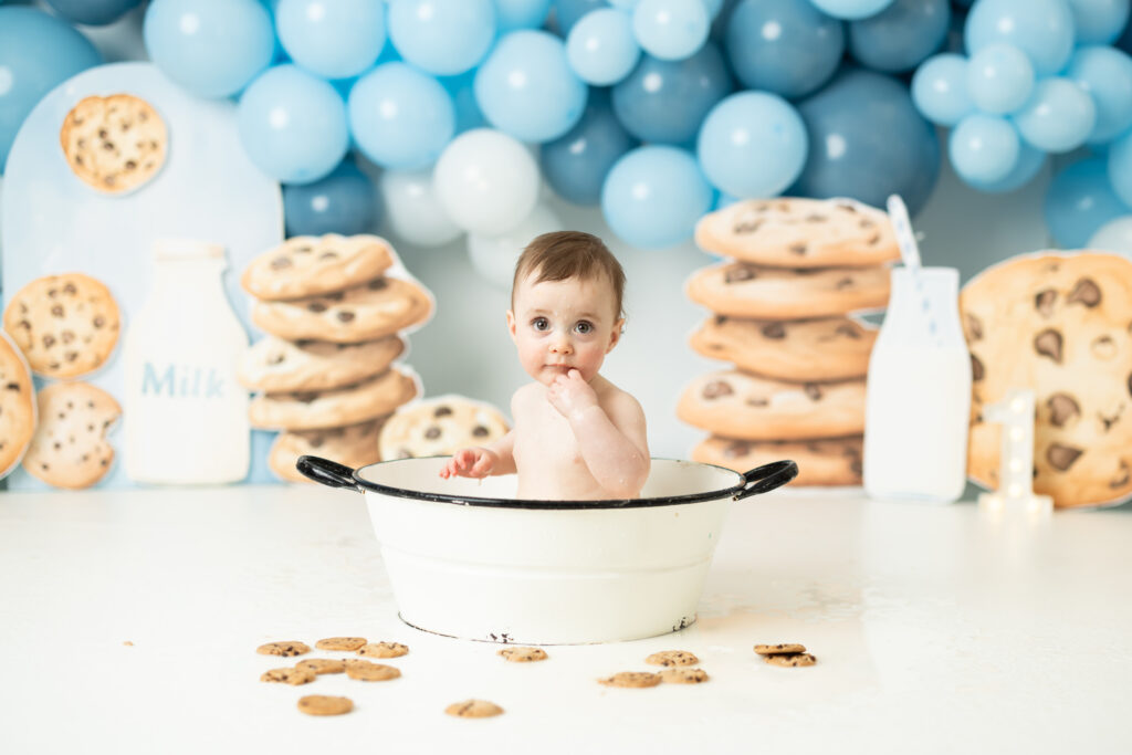 baby enjoying a milk bath at first birthday pictures 