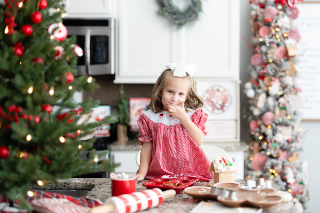 Gingerbread Kitchen Christmas mini session in Canton, GA with kids decorating holiday gingerbread houses.