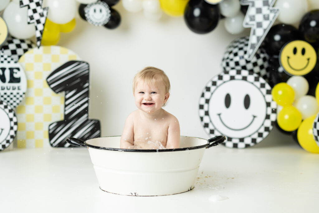 Baby splashing in bubble bath during Smile, Smash & Splash package.