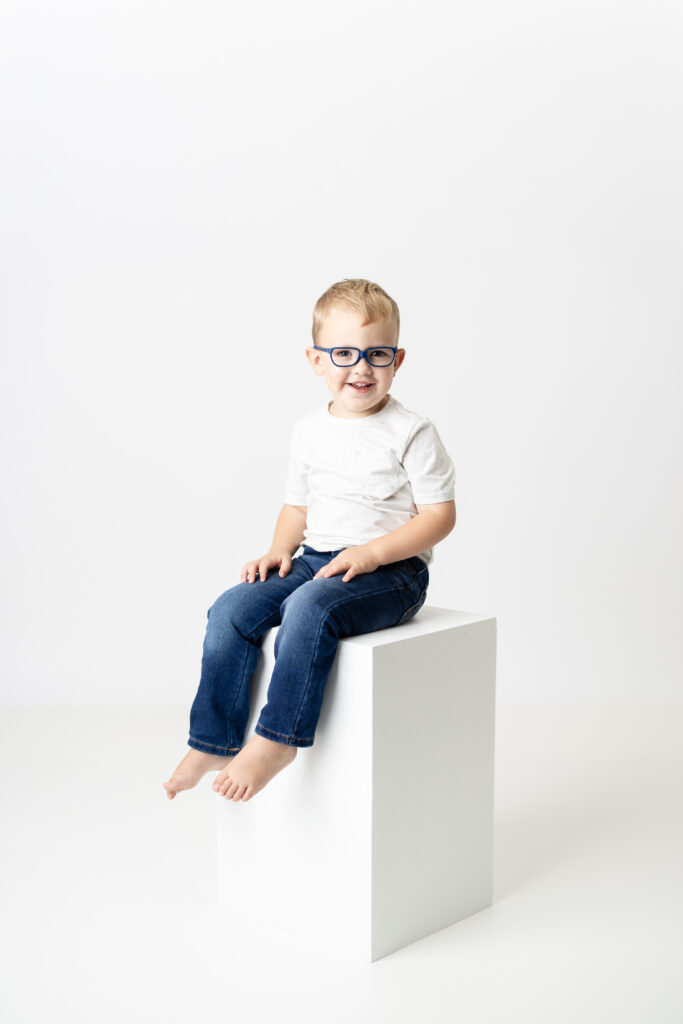 Little boy smiling during simple white studio birthday session in Canton GA