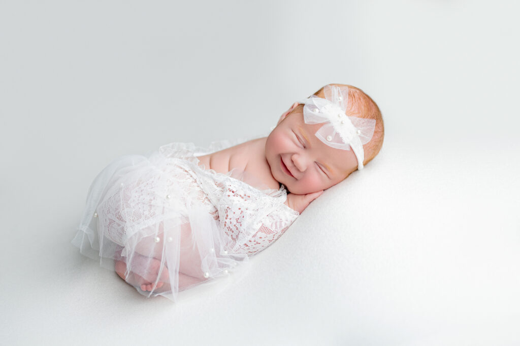 newborn baby girl in white lace outfit with tutu