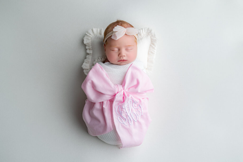 Close-up of sleeping newborn girl with wispy red hair.