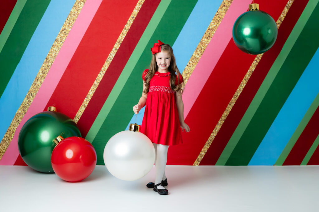 Close-up of holiday ornaments and decorations from Colorful Christmas backdrop with child smiling