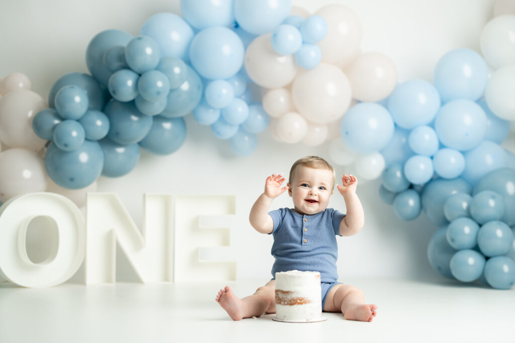 Baby clapping during simple blue cake smash in Canton GA studio