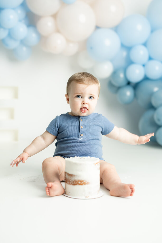 Close-up of blue cake with balloons and props