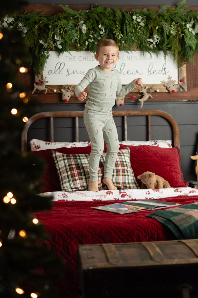Boy opening plaid gift box on holiday bed set.
