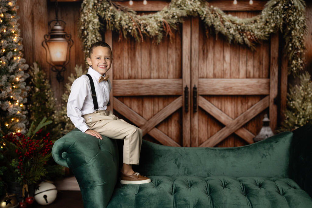 Child smiling during Studio Aspen Christmas Photos Canton GA on rustic holiday set