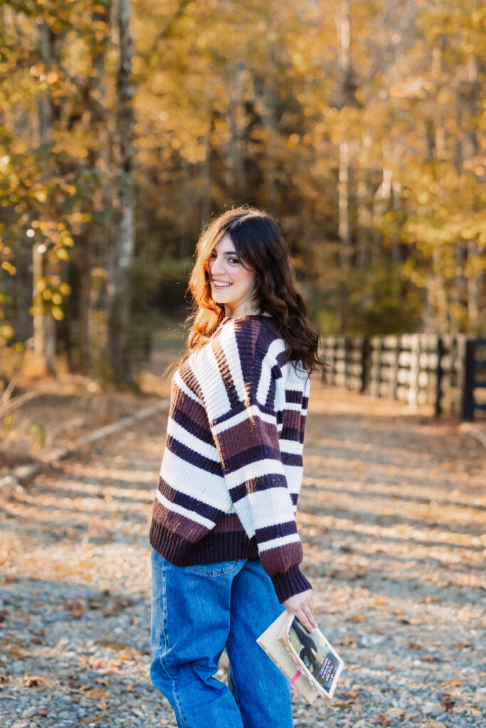 Senior holding books during fall senior portrait session
