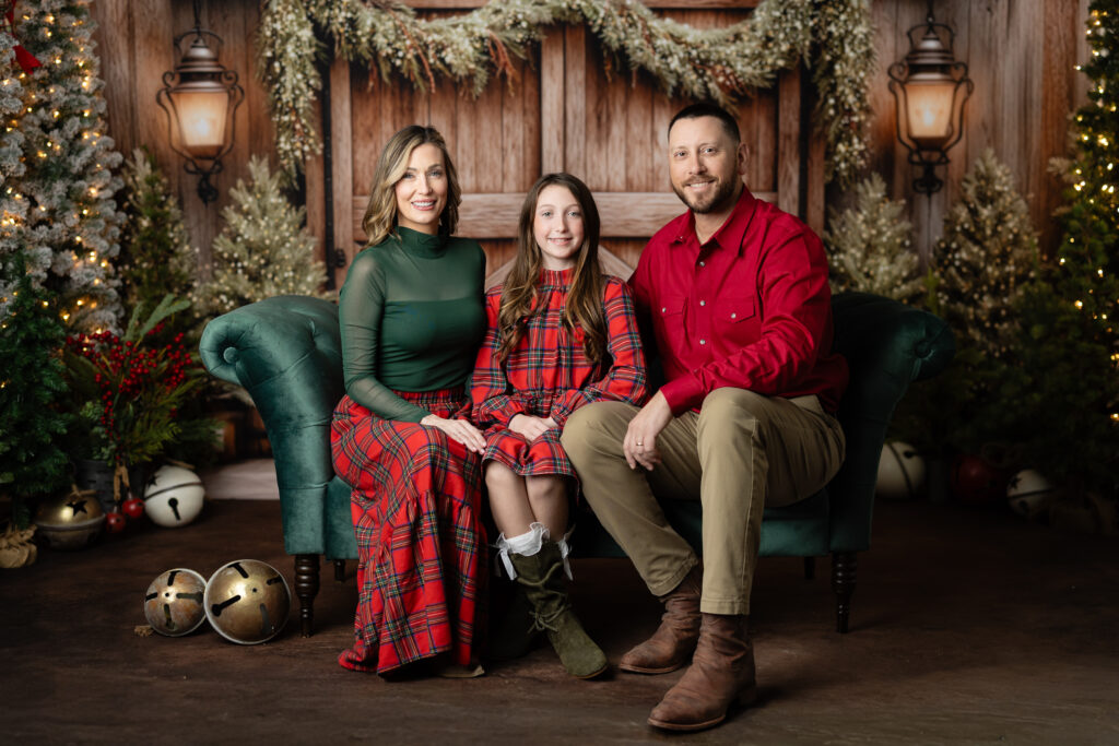 Family posing on green velvet sofa during Studio Aspen Christmas Photos Canton GA