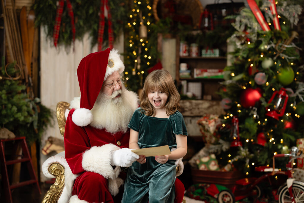 Child laughing with Santa while opening a letter during A Date with Santa 2026 Canton GA holiday photo session.