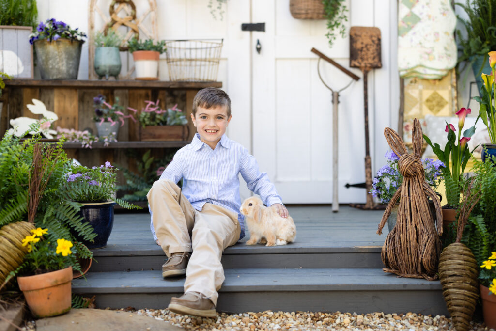 Child sitting on spring bunny set surrounded by flowers Canton GA