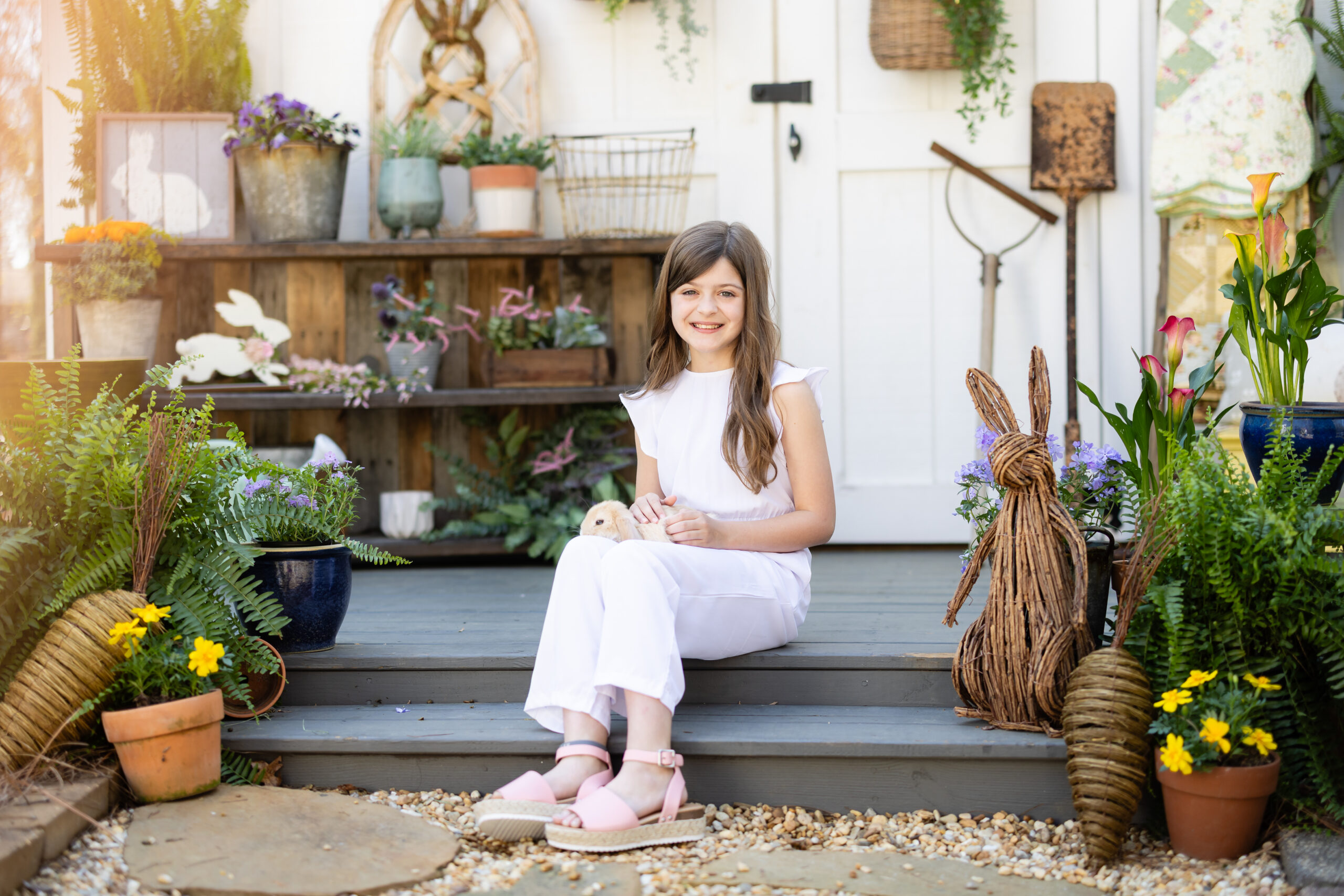 girl sitting on decorated porch holding a bunny