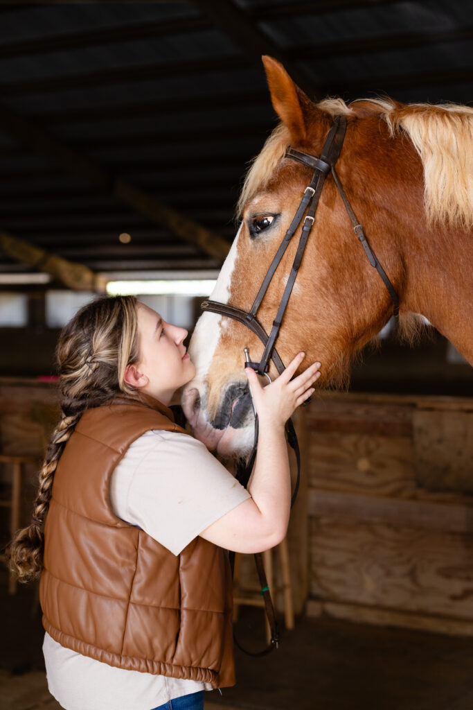 Senior girl looking at horse in barn during senior session Canton GA