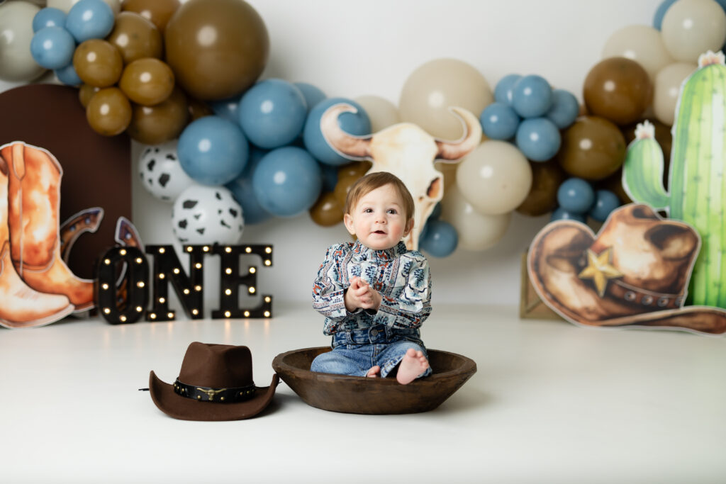 Cowboy themed cake smash setup with balloons and western props in Canton GA photography studio