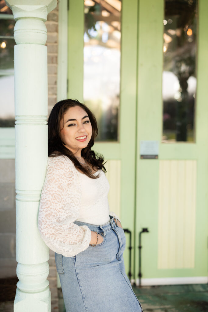 High school senior portrait sitting by green doors West Milford Farm Canton GA