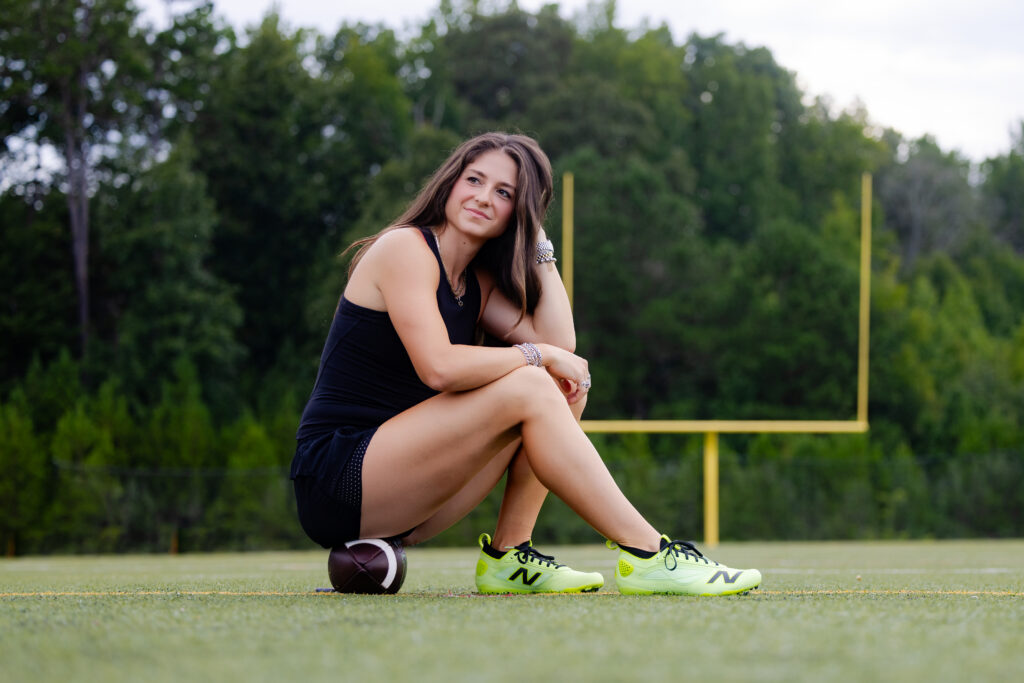 Female athlete branding portrait with a football on the field