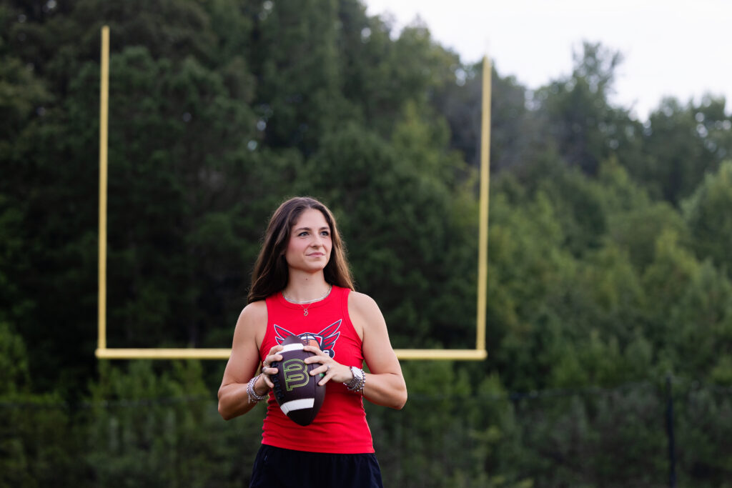 Coach Dakota holding a football during her DH Flag Football branding session